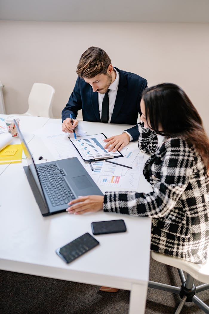 Business professionals analyzing data and collaborating on a project in a modern office setting.