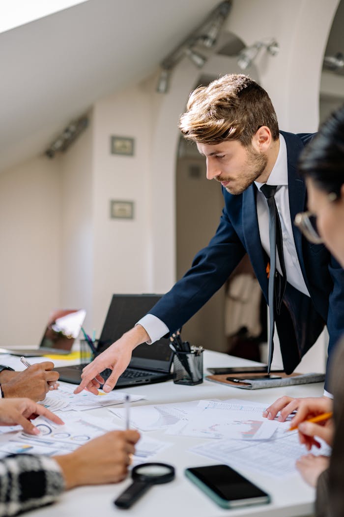 Diverse business team planning together with documents, laptop, and teamwork in modern office.